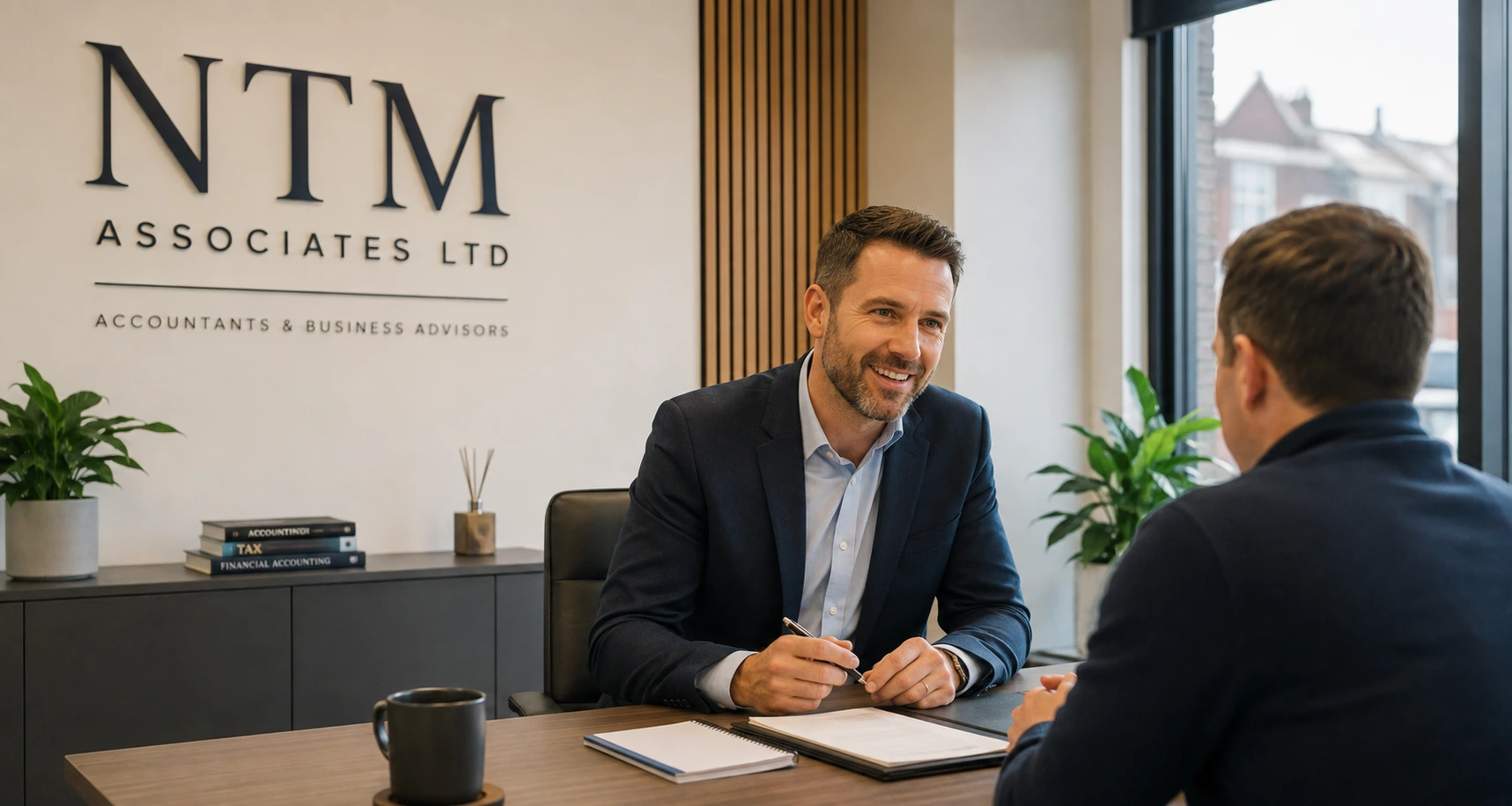 NTM Associates accountant reviewing financial charts, calculator and laptop